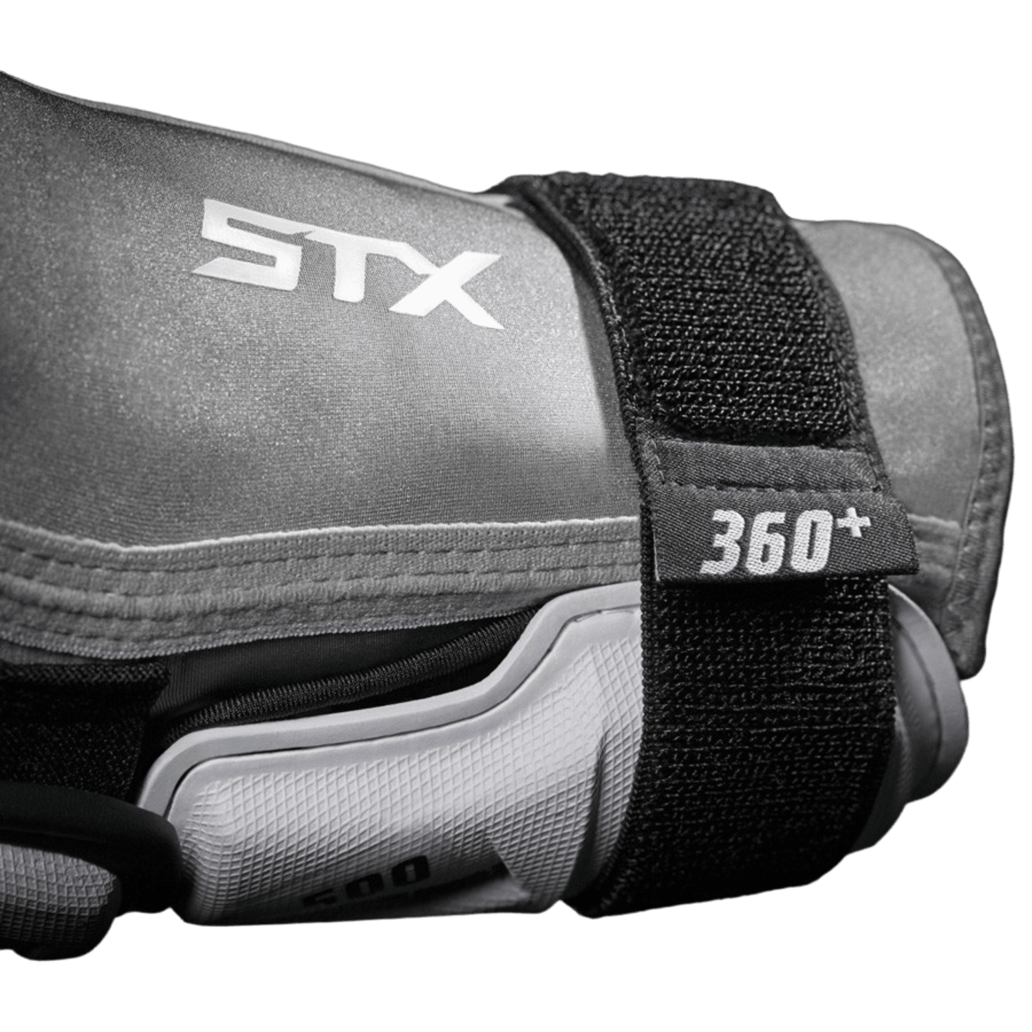 Close-up of the STX Stallion 500 Arm Guards, featuring low-profile gray protective sports gear with a black strap displaying white text that reads "360+." The brand "STX" is visible prominently on the upper part, highlighting its textured and durable surface.